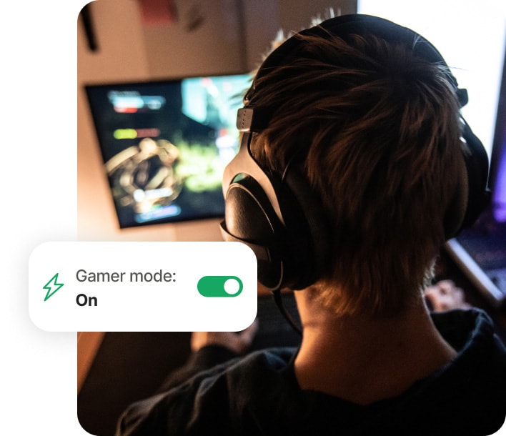 Poika pelaa pelejä tietokoneella ja käyttää Norton 360 for Gamers -sovellusta.
